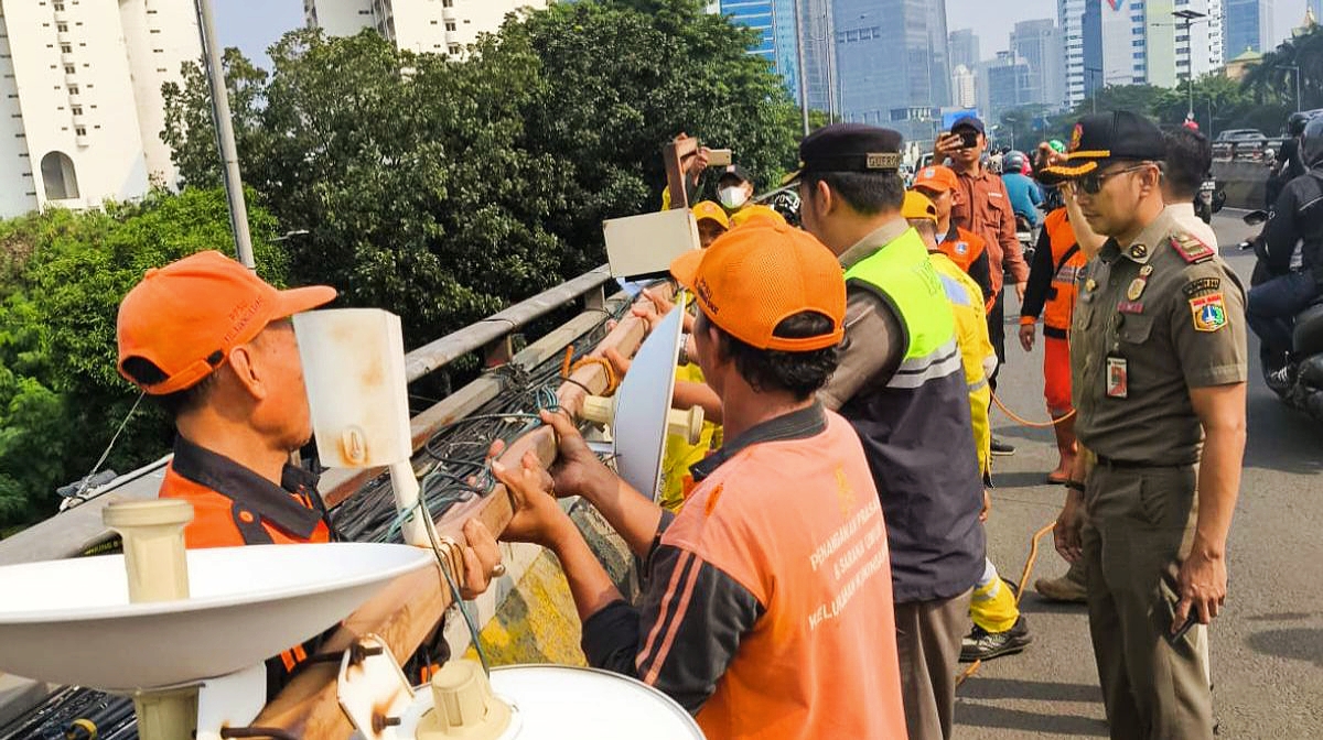 Antisipasi Korban, Petugas Copot Tiang CCTV dan Antena Ilegal yang Miring di Flyover Gatot Subroto