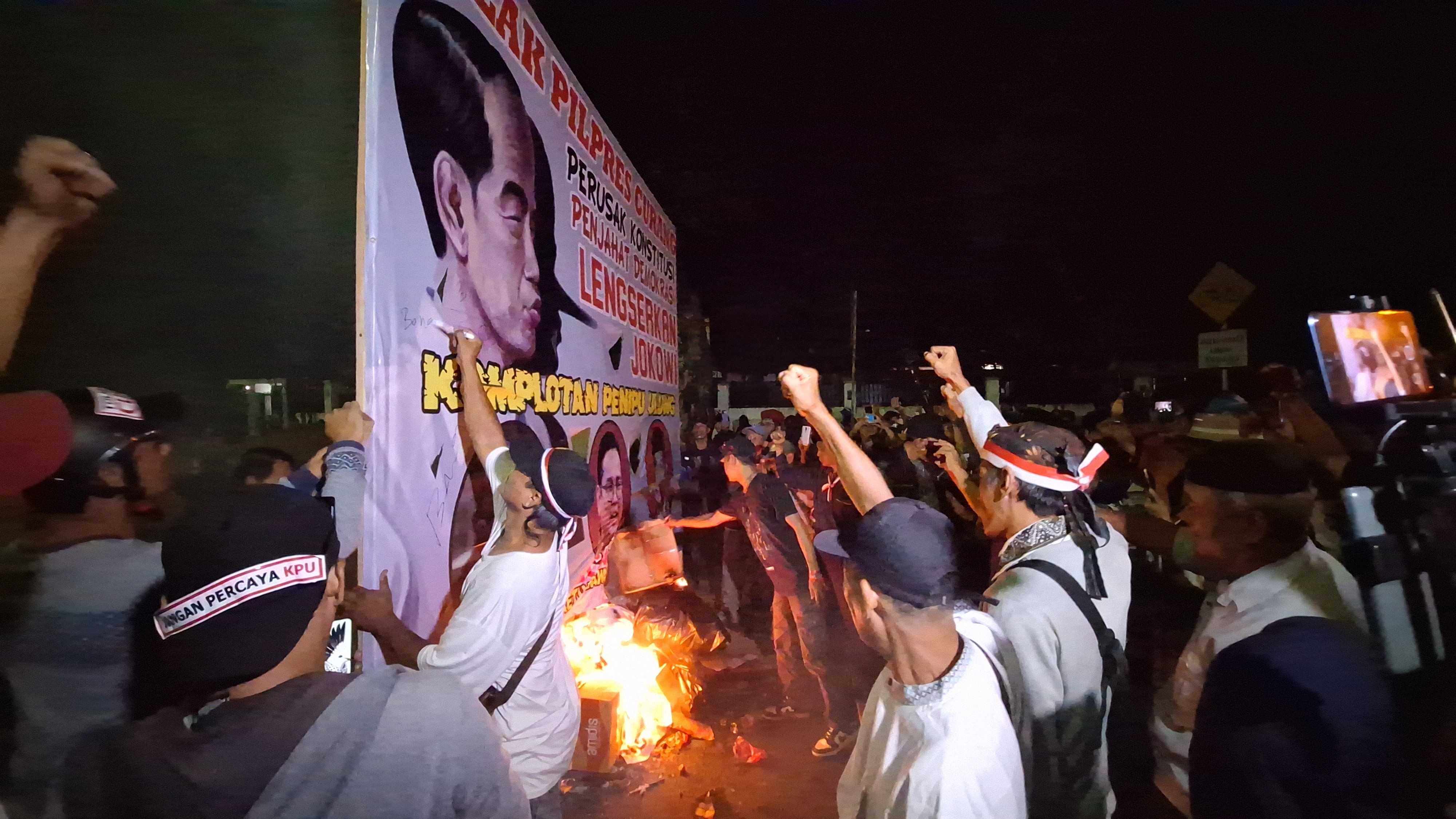 Saat Massa Tolak Pemilu Curang Bakar Spanduk Bergambar Presiden Jokowi di Depan KPU