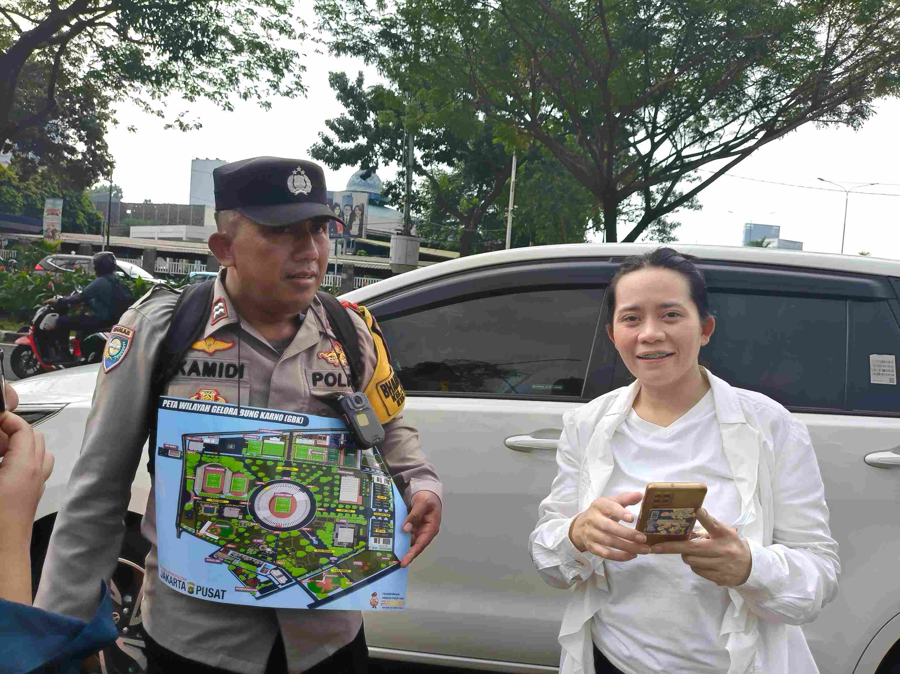 Bantu Jemaat Misa, Anggota Bhabinkamtibmas Polsek Metro Menteng Keliling Bawa Denah Acara di GBK