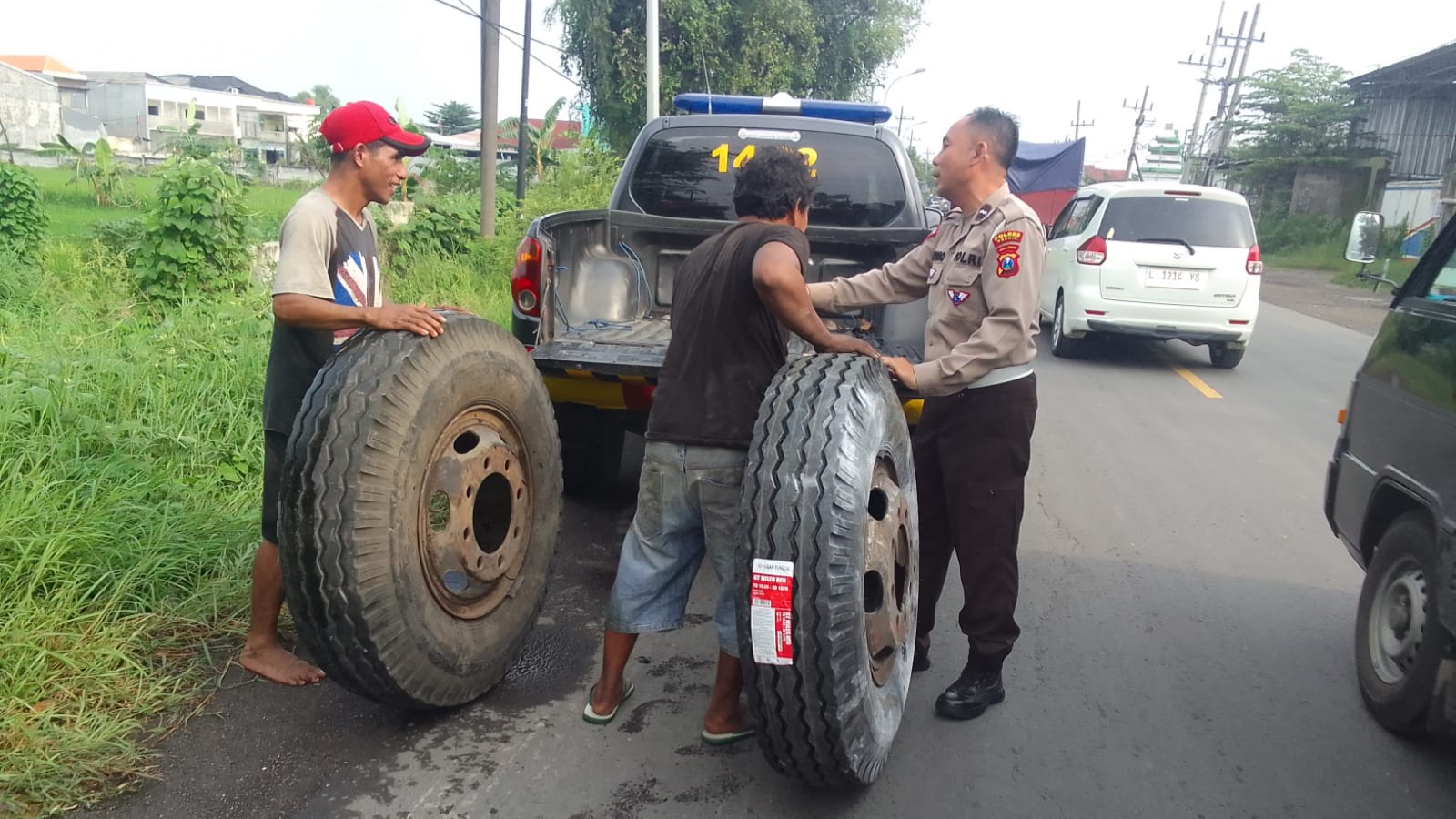 Sungguh Mulia, Polisi di Gresik Bantu Sopir Truk Ganti Ban di Tengah Padatnya Lalu Lintas