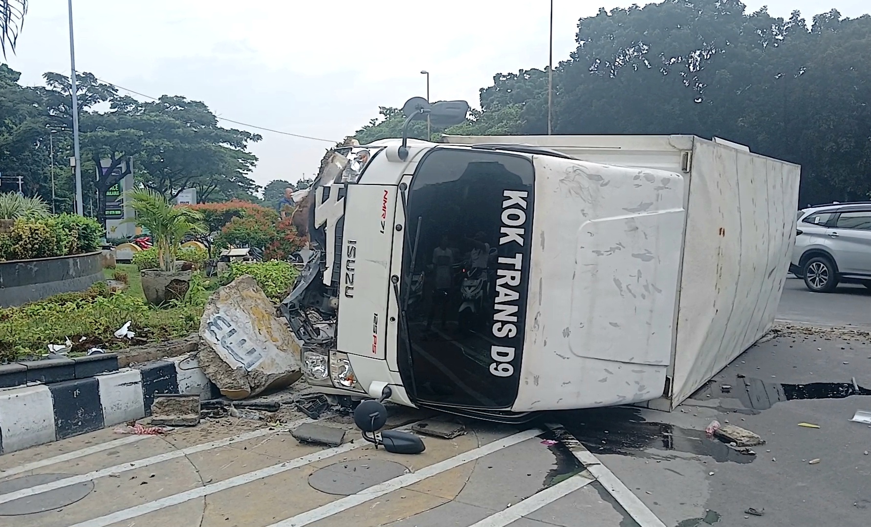 Hindari Pemotor, Mobil Boks Terguling Tabrak Beton dan Nyaris Timpa Monumen Ondel-Ondel