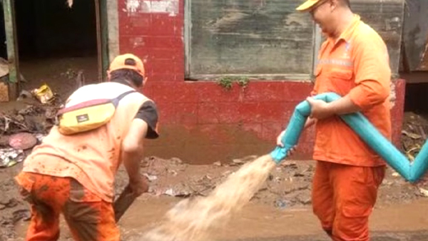 Luapan Kali Ciliwung Mulai Surut, Petugas Bersihkan Sisa Lumpur Banjir di Rumah Warga