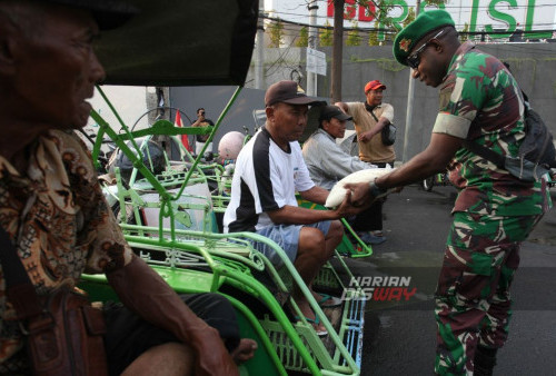 Prajurit TNI Angkatan Darat membagikan bantuan paket berupa beras kepada tukang becak di Wonokromo, Surabaya, Jawa Timur, Senin, 11 Desember 2023. Pembagian paket beras sebanyak 250 paket dengan berat per paket 5 kilogram itu untuk membantu meringankan ekonomi para tukang becak di kawasaan tersebut sekaligus untuk memperingati HUT ke-78 Yonif 516/CY Kodam V/Brawijaya. (Julian Romadhon/Harian Disway)
