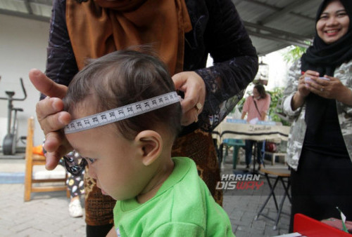 Kader posyandu mengukur lingkar kepala anak saat pelaksanaan Pos Pelayanan Terpadu (Posyandu) di Kawasan Perumahan Surya Asri 2 Jumputrejo, Sukodono, Sidoarjo, Jawa Timur, Sabtu, 11 November 2023. Badan Kependudukan dan Keluarga Berencana Nasional (BKKBN) Jawa Timur telah menargetkan angka prevalensi stunting di Jawa Timur tahun 2023 mengalami penurunan 16 persen dan pada tahun 2024 ini kembali turun menjadi 14 persen. (Lilik Isharyono untuk Harian Dsway)
