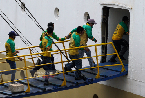 Sejumlah buruh angkut atau yang akrab disebut portir berebut menaiki tangga memasuki kapal yang bersandar di Pelabuhan Tanjung Perak, Surabaya, Jawa Timur. Foto: Julian Romadhon