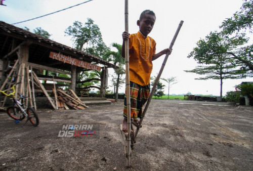 Seorang anak sedang memainkan permainan tradisional Egrang saat ngabuburit Kampung Lali Gadget (KLG), Desa Pagerngumbuk, Wonoayu, Sidoarjo, Jawa Timur. Minggu (26/3/2023). Sebanyak 20 anak memainkan permainan tradisional yang digelar oleh Kampung Lali Gadget (KLG) Foundation. (foto: Moch Sahirol)