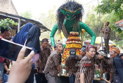 Warga mengikuti rangkaina Sedekah Bumi yang digelar di Bangkingan, Surabaya, Jawa Timur, Minggu, 27 Agutus 2023. Sedekah Bumi atau ruwat desa dengan 20 wadah sajian hasil bumi yang 9 diantaranya berukuran raksasa berbentuk hewan maupun tokoh fiktif tanah jawa itu digelar dalam rangka memperingati hari ulang tahun Kampung Bangkingan yang dilakukan di Punden Ajisaka, Bangkingan. Sedekah Bumi tersebut sebagai wujud rasa syukur kepada tuhan yang maha esa atas rizki yang diberikan kepada para warga Bangkingan.  (Ahmad Rijaluddin Erlangga/Harian Disway)

