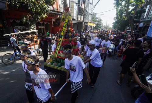 Warga menggotong gunungan sayur dan buah saat Bersi Desa di Dukuh Kupang, Surabaya, Jawa Timur, Minggu, 6 Agustus 2023. Bersih Desa atau Sedekah Bumi dengan menggelar Kirab Budaya serta mengarak gunungan dari berbagai hasil bumi tersebut sebagai wujud rasa syukur kepada Tuhan atas hasil bumi yang melimpah. (Julian Romadhon/Harian Disway)
