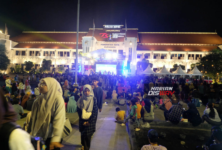 Taman Surya benar-- benar menjadi milik warga Kota Surabaya. Masyarakat berbagai usia tumplek bleg memenuhi halaman Balai Kota. Bahkan , disisi timur Taman Surya juga dibuka lapak-lapak UMKM. Warga yang mengajak anak dan istrinya tidak lagi khawatir mencari makanan sambil menunggu diletupkannya kembang api. Beberapa pedagang tampak meggoreng aneka camilan. Tenda tenda yang mereka rakit menjadi pelindung turunnya gerimis yang kian menebal.
Foto : Boy Slamet- Harian Disway 