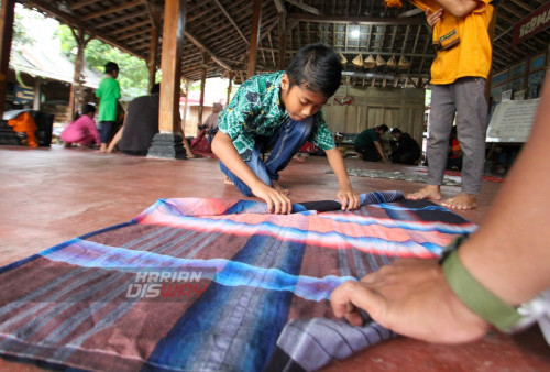 Sejumlah anak mempersiapkan sarung untuk dijadikan alat permainan tradisional saat ngabuburit Kampung Lali Gadget (KLG), Desa Pagerngumbuk, Wonoayu, Sidoarjo, Jawa Timur. Minggu (26/3/2023). (foto: Moch Sahirol)