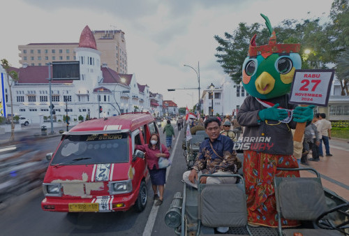 Berdiri di atas Jeep, si Jalih tampak menunjukkan papan bertuliskan tanggal yang merupakan pelaksanaan Pilkada Serentak. Pengendara sepanjang jalan di Kawasan Kota Lama tampak memperhatikan adegan itu yang merupakan sosialisasi KPU Surabaya tentang pelaksanaan Pilkada Serentak. Foto : BoySlamet- harian Disway