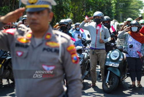 Sejumlah pengendara hormat saat berada di lampu merah Jalan Polisi Istimewa, Surabaya, Jawa Timur,  Kamis, 17 Agustus 2023. Kegiatan menghentikan sejenak kendaraan bermotor dilokasi tersebut untuk mengambil sikap sempurna dalam rangka HUT Kemerdekaan RI memperingati detik - detik pembacaan Proklamasi. (Julian Romadhon/Harian Disway)