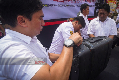 Polisi berpakaian sipil menata barang bukti narkoba jenis sabu jelang ungkap kasus di Halaman Polrestabes Surabaya, Jawa Timur, Senin (13/3/2023). Polrestabes Surabaya berhasil mengamankan dua tersangka beserta barang bukti Narkoba jenis sabu seberat 24,1 kg yang berasal dari Pekanbaru, Riau. Kedua tersangka yang kini ditahan dijerat Pasal 114 Ayat (2) Jo. Pasal 132 Ayat (1) Subs Pasal 112 Ayat (2) Jo. Pasal 132 Ayat (1) UU RI No. 35 Tahun 2009 tentang narkotika Pidana penjara paling singkat 6 tahun dan maksimal seumur hidup atau hukuman mati. (foto; Julian Romadhon)
