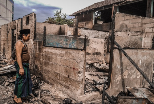 Seorang warga menyaksikan kondisi rumah yang terkena kebakaran di Pasar Ciputat