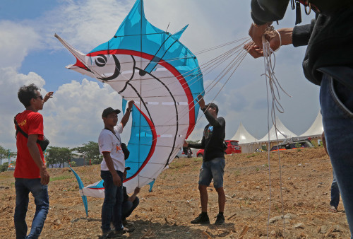 Hiren Eko, Suharno dan Edi Hendra dari Kabupaten Ponorogo bersiap menerbangkan layang -layang berbentuk Blue Marlin. Mereka tergabung dalam kelompok Gumelang. 