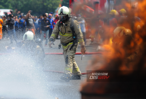 Sejumlah petugas Pemadam Kebakaran (Damkar) berusaha menjinakkan kobaran api saat simulasi penanganan kebakaran dan penyelamatan korban usai upacara Hari Ulang Tahun (HUT) Damkar ke-105, di lapangan Kodam V/Brawijaya, Surabaya, Jawa Timur, Jumat, 1 Maret 2024. Upacara peringatan HUT ke-105 Damkar tersebut diikuti oleh seluruh Dinas Kebakaran dan Penanggulangan Bencana se Indonesia. Dalam kegiatan tersebut Dinas Pemadam Kebakaran (Damkar), mengusung tema 