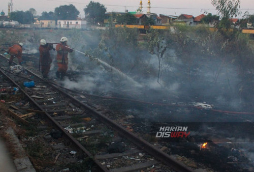 Petugas pemadam kebakaran melakukan pembasahan api saat terjadi kebakaran lahan di Stasiun Sidotopo Surabaya, Jawa Timur, Selasa, 12 September 2023. Kebakaran lahan tersebut membuat panik warga sekitar karena dekat dengan permukiman warga dan kebakaran tersebut diduga karena intensitas kemarau yang mengakibatkan lahan mudah terbakar. (Ma'ruf Zaky/Harian Disway)
