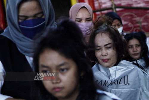 Kapster melakukan proses potong rambut kepada warga di Masjid Muhammad Cheng Hoo, Surabaya, Jawa Timur, Senin (10/4/2023). Kegiatan berbagi dan potong rambut massal secara gratis dalam bulan Ramadhan yang digelar oleh Ngaji Komunitas Salon (Ngasal) Surabaya tersebut itu diikuti sekitar 500 orang anak yatim dan Duhafa. (foto: Julian Romadhon)