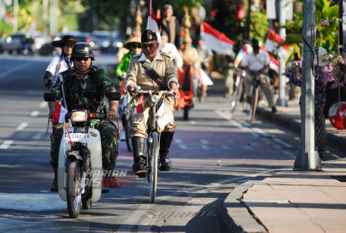 Anggota Komunitas Sepeda Kuno Patriot Sejati (Senopati) bersepeda mengelilingi Kota Surabaya, Jawa Timur, Kamis, 17 Agustus 2023. Komunitas Senopati berkeliling menyusuri jalan-jalan di Surabaya dengan membawa bendera merah putih tersebut dalam rangka memperingati Hari Ulang Tahun (HUT) ke-78 Republik Indonesia. (Julian Romadhon/Harian Disway)