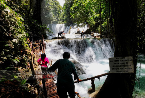 Pengunjung melihat keindahan air terjun Piala di Luwuk, Banggai, Sulawesi Tengah, Jumat (17/3/2023). Wisata alam Air Terjun Piala merupakan wisata andalan daerah tersebut yang jaraknya hanya di tempuh 10 menit dari pusat kota Luwuk, tak hanya itu Air Terjun ini dijadikan sebagai sumber pembangkit listrik oleh pihak PLN. Sehingga di dekat air terjun ini terdapat PLTMH yaitu pembangkit listrik yang menggunakan tenaga mini hidro. (foto: Julian Romadhon)