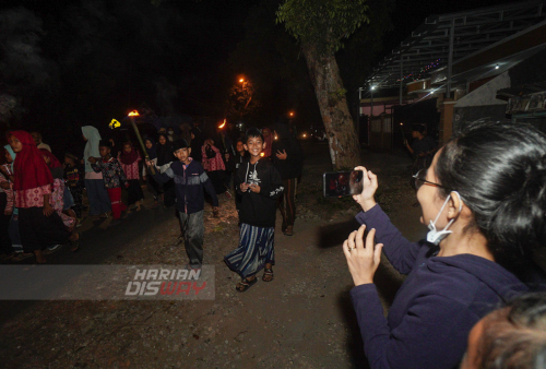 Warga mendokumentasikan takbir keliling di Lakarsantri, Surabaya, Jawa Timur, Minggu (1/5). Takbir keliling yang diikuti puluhan warga dengan berjalan kaki serta mobil pick up dari kampung ke kampung itu untuk menyambut malam hari raya Idul Fitri 1443 H. Foto: Julian Romadhon
