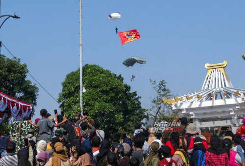 Warga menyaksikan Demo Terjun Payung dari Pasmar-2 di acara Kirab Kota Surabaya dalam rangka HUT TNI AL ke-78 tahun 2023, di Depan kantor Gubernur Jatim, Jalan Pahlawan, Surabaya, Jawa Timur, Minggu 17 September 2023. Kirab Kota Surabaya yang diikuti oleh peserta dari Kodiklatal , Koarmada II, AAL, Puspenerbal, STTAL, Pasmar-2 Marinir dan RSPAL dr. Ramelan tersebut dalam memperingati HUT TNI AL ke-78 tahun 2023, dengan mengusung tema“Dengan Semangat Jalesveva Jayamahe, Terus Melaju untuk Indonesia Maju” yang bertujuan mengenalkan Surabaya sebagai Navy City. (Moch Sahirol/Harian Disway)