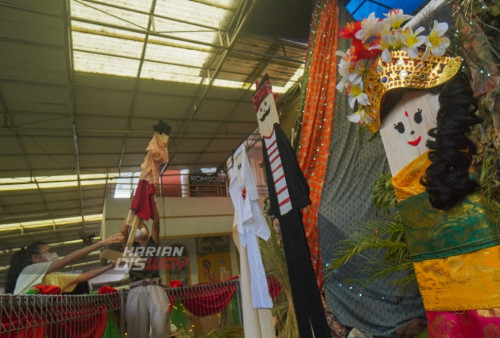 Umat Kristiani menata sejumlah papan manusia yang diletakkan di bawah pohon natal setinggi 4 meter yang dililit 5 lembar batik cap dengan panjang masing-masing 5 meter yang dililit berbentuk pohon Natal di Greja Katolik Kristus Radja, Surabaya, Jawa Timur, Sabtu (17/12/2022). Selain itu ada pula dekorasi orang-orangan yang terbuat dari papan dengan menggunakan pakaian pakaian adat kekayaan Nusantara.
