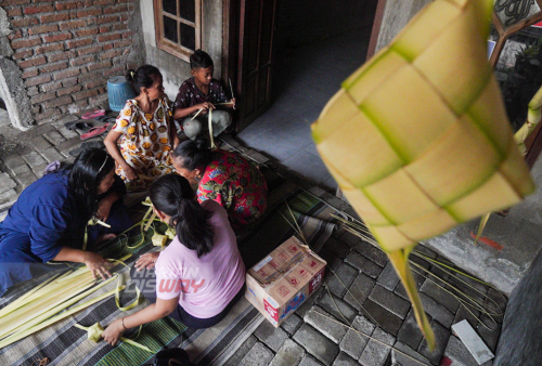 Warga belajar membuat cangkang ketupat di jalan Tubanan Indah 1, Surabaya, Jawa Timur, Minggu (8/5/2021). Pembelajaran membuat cangkang ketupat tersebut diinisiasi oleh Trip for Education (TFE) dan Kampoeng Dolanan (KD) dengan tujuan anak-anak dan warga dikawasan tersebut mampu menganyam sendiri janur menjadi cangkang ketupat sehingga tradisi membuat ketupat untuk Lebaran Ketupat tetap lestari. Foto: Julian Romadhon

