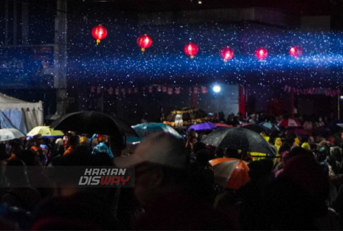 Warga menggunakan payung menuju area pagelaran Festival Cap Go Meh yang diguyur hujan di Kya-kya, Kembang Jepun, Surabaya, Jawa Timur, Minggu (12/2/2023). Meski hujan deras mengguyur Kota Surabaya, namun warga tetap antusias menyaksikan perayaan Festival Cap Go Meh. Dalam acara Festival Cap Go Meh tersebut melibatkan sebanyak 200 peserta yang mengikuti Parade Kostum Unik. Dengan adanya Festival Cap Go Meh tersebut diharapkan agar dapat memancing masyarakat berkunjung ke kawasan Pecinan Kembang Jebun. (foto: Julian Romadhon)