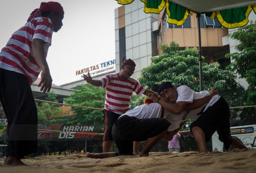 Dua wasit mendampingi pegulat yang sedang mengadu kekuatan saat di arena Gulat tradisional yang beralasan jerami di Lapangan Persahabatan Kampus Universitas Wijaya Kusuma (UWK) Surabaya, Jawa Timur, Selasa (20/6/2023). Gulat tradisional atau yang lebih dikenal dengan Gulat Okol, olahraga Gulat asal Gresik, Jawa Timur itu menjadi bagian dari hari jadi Universitas Wijaya Kusuma Surabaya (UWKS) ke 42, tersebut merupakan wujud kegembiraan pihak UWKS atas mendapatkan posisi ke 3 terbaik se-Surabaya dan ke 7 se-Jatim.
