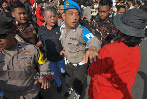 Polisi mengamankan ketua DPRD Jatim, Kusnadi, dari amukan sejumlah mahasiswa saat berlangsungnya aksi unjuk rasa mendesak pengesahan UU Perampasan Aset dan mencabut undang-undang Cipta Kerja di Gedung DPRD Jatim, Surabaya, Jawa Timur, Rabu (12/4/2023). Mahasiswa menuntut DPRD Jawa Timur untuk ikut menolak pengesahan Perppu Cipta Kerja Nomor 2 tahun 2022 yang dianggap tidak memihak kepentingan buruh dan pekerja di Indonesia. (foto: Julian Romadhon)