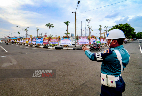 Karangan bunga sebagai ucapan selamat kepada pejabat baru Pangkoarmada II berjejer rapi di jalan pintu masuk menuju Dermaga Ujung Koarmada II Surabaya, Jawa Timur. Senin (27/2/2023). (foto: Moch Sahirol)