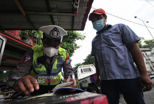 Zainul petugas Polisi Lalulintas Polsek Sukolilo memberikan surat teguran kepada driver yang melanggar lalu lintas (melintasi markah jalan) di Jalan Dr. Ir. H. Soekarno, Surabaya, Jawa Timur, Jumat (24/2/2023). Tilang manual berfokus menindak pelanggaran kendaraan yang tidak sesuai spesifikasi teknis (spektek). (foto: Julian Romadhon)
