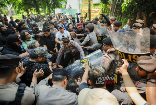 Sekelompok orang  berusaha menghalau petugas kepolisian saat eksekusi pengosongan bangunan di jalan Gading Pantai II/12 Surabaya, Jawa Timur, Rabu, 11 Oktober 2023. Eksekusi satu unit bagunan rumah yang dilakukan oleh Pengadilan Negeri Kota Surabaya tersebut sempat berlangsung ricuh karena mendapatkan perlawanan dari sekelompok orang sehingga polisi melakukan tindakan penghalauan. (Julian Romadhon/Harian Disway)