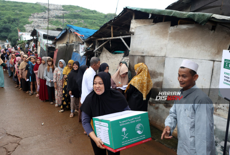 Warga membawa bantuan paket pangan Ramadhan 1446 H melalui BAZNAS ke warga Kampung Sumur Batu di Bantar Gebang, Bekasi, Jawa Barat, Selasa (18/2/2025). BAZNAS akan menyalurkan bantuan sebanyak 7.911 paket pangan Ramadhan 1446 H dari lembaga bantuan kemanusiaan yang didirikan Raja Salman bin Abdulaziz Al-Saud, King Salman Humanitarian Aid & Relief Centre. HARITSAH ALMUDATSIR/HARIAN DISWAY