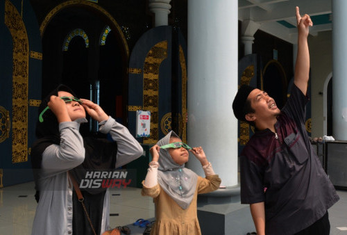 (kiri-kanan) Aulia Syafa, Alina Sabilla, Miftahudin Azmi warga Surabaya melihat gerhana matahari dengan menggunakan kacamata anti sinar UV di Masjid Al Akbar, Surabaya Jawa Timur, Kamis (20/4/2023). Shalat gerhana matahari merupakan shalat sunnah anjuran dari Rasulullah Saw dan keutamaannya adalah supaya manusia mengingat kuasa Allah, mendatangkan ridlo juga ampunan Allah, dan menghadirkan rasa takut kepada Allah SWT. (foto: Syahrul Rozak Yahya)