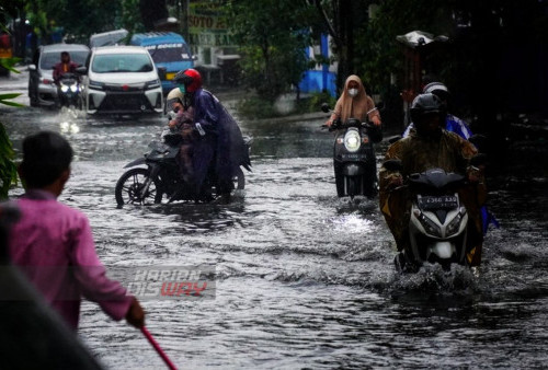 Pengendara menerjang genangan air yang ada di kawasan Dukuh Kupang Surabaya, Jawa Timur, Kamis (30/3/2023). Hujan deras yang mengguyur selama sekitar satu jam itu menyebabkan sejumlah kawasan dan ruas jalan raya di kota Surabaya terendam air dengan ketinggian 40 cm sampai 60 cm. (foto: Julian Romadhon)
