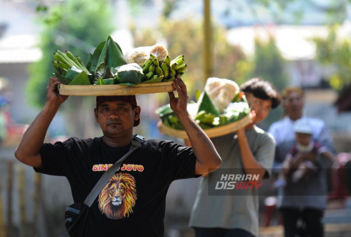 Warga membawa tumpeng yang diletakan di Punden Mbah Singo Joyo, Made, Sambikerep, Surabaya, Jawa Timur, Minggu, 15 Oktober 2023. Sedekah Bumi atau ruwat desa dengan 4 gunungan hasil bumi berukuran raksasa itu digelar sebagai wujud rasa syukur kepada tuhan yang maha esa atas rizki yang diberikan kepada para warga Made, Sambikerep. (Julian Romadhon/Harian Disway)