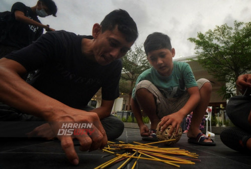 Warga mencoba permainan tradisional Cutikan sambil menunggu waktu berbuka puasa (ngabuburit) di Alun-alun Surabaya, Jawa Timur, Minggu (26/3/2023). Ngabuburit dengan bermain permainan tradisional bersama Komunitas Kampoeng Dolanan Surabaya itu sekaligus mengkampanyekan beragam permainan tradisional serta mengingatkan kembali tentang sebuah tradisi ngabuburit positif dalam lingkungan anak-anak. (foto: Julian Romadhon)