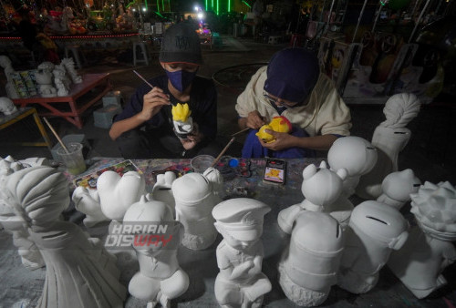 Sejumlah anak dengan teliti mengecat Celengan Karakter kartun di Alun-alun Blora, Jawa Tengah, Jumat (21/4/2023). Alun-alun Kota Blora menjadi tempat edukasi para anak dimasa liburan, tak hanya permainan anak, di lokasi tersebut terdapat penjual paket lukis celengan karakter berbahan semen putih yang dijual dari Rp5 ribu hingga Rp25 ribu. Paket lukis celengan karakter tersebut banyak dibeli untuk mengedukasi anak dan sebagai media untuk belajar menabung. (foto: Julian Romadhon)