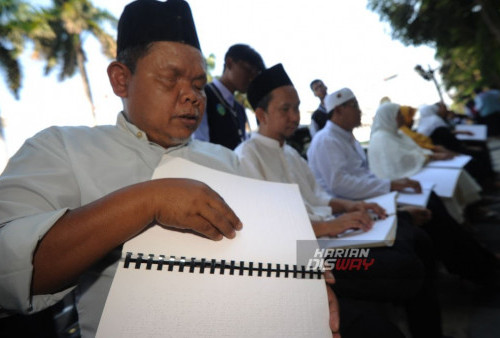 Sejumlah penyandang tuna netra membaca Al Quran braille di trotoar Jalan Tunjungan, Surabaya, Jawa Timur, Sabtu, 21 Oktober 2023. Kegiatan yang diikuti oleh 28 orang penyandang tuna netra mengikuti kegiatan membaca Al Quran braille di trotoar dengan tujuan untuk memotivasi sekaligus mengajak masyarakat untuk mencintai Al Quran meski dengan keterbatasan. (Julian Romadhon/Harian Disway)
