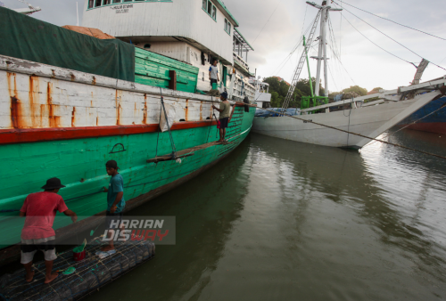 Pekerja mengecat lambung kapal yang bersandar di pelabuhan tradisional Kalimas Surarabaya, Jawa Timur, Minggu (1/5). Saat ini ekspedisi via kapal layar motor mulai didominasi oleh sejumlah kebutuhan rumah tangga untuk menyambut lebaran. Foto: Julian Romadhon