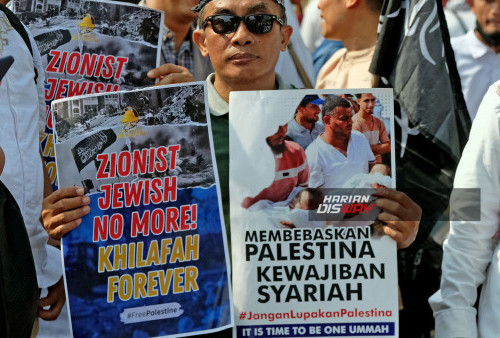 Dengan membentangkan poster berisi desakan untuk membebaskan Palestina dari kekejaman Zionis , seorang peserta aksi  bersama ribuan massa aksi lainnya tampak  berhenti di depan Gedung Negara Grahadi menggelar gerakan dukung Palestina di jalan Gubernur Suryo, tepatnya di seberang  gedung Negara Grahadi Surabaya 2 Juni 2024.  Peseta aksi yang jumlahnya mencapai ribuan itu sebelumnya juga melakukan longmarch dengan rute Jalan Gubernur Suryo- Jalan Basuki Rachmat dan finish di seberang Grahadi. Foto : Boy Slamet- Harian Disway.