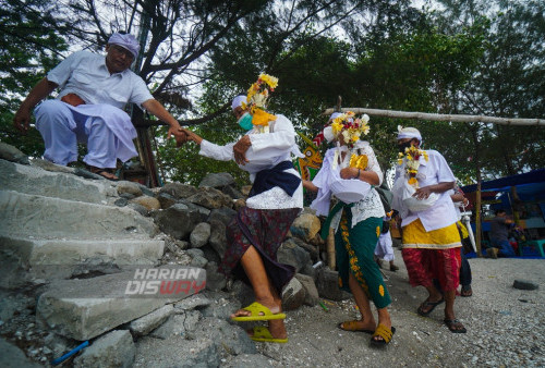 Umat Hindu membawa perangkat upacara yang merupakan simbol arwah anggota keluarganya dalam upacara Ngaben massal saat akan dilarung ketengah lautan.