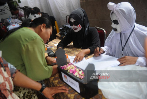 Petugas KPPS mengenakan kostum hantu saat bertugas di Tempat Pemungutan Suara (TPS) 23 di Makam Rangkah, Surabaya, Jawa Timur, Rabu, 14 Februari 2024. Petugas menggunakan kostum bertema hantu tersebut bertujuan untuk menarik warga dilingkungan tersebut agar tertarik untuk menggunakan hak pilihnya dalam Pemilu 2024. (Julian Romadhon/Harian Disway) 
