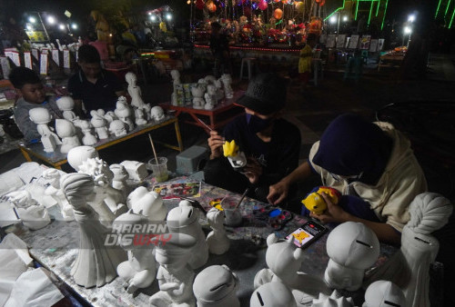 Melukis Celengan Karakter di Alun-alun Kota Blora, Jawa Tengah selalu dipadati anak-anak saat musim libur tiba. Alun-alun Kota Blora menjadi tempat edukasi para anak dimasa liburan, tak hanya permainan anak, di lokasi tersebut terdapat penjual paket lukis celengan karakter berbahan semen putih yang dijual dari Rp5 ribu hingga Rp25 ribu. Paket lukis celengan karakter tersebut banyak dibeli untuk mengedukasi anak dan sebagai media untuk belajar menabung. (foto: Julian Romadhon)