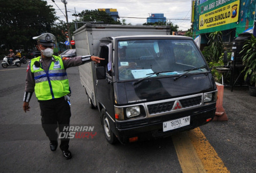 Zainul petugas Polisi Lalulintas Polsek Sukolilo menghentikan mobil Box yang melanggar lalu lintas (melintasi markah jalan) di Jalan Dr. Ir. H. Soekarno, Surabaya, Jawa Timur, Jumat (24/2/2023). Tilang manual di Surabaya telah direalisasikan Februari ini. Pemberlakuan itu untuk menindak pelanggaran-pelanggaran yang tidak bisa ditangani sistem Electronic Traffic Law Enforcement (ETLE). (foto: Julian Romadhon)