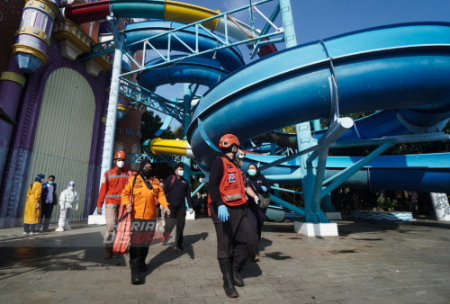 Petugas Badan Penanggulangan Bencana Daerah (BPBD) Kota Surabaya melintasi Seluncuran air di Waterpark Kenjeran, Surabaya, Jawa Timur, Sabtu (7/5). Sebanyak 16 pengunjung jadi korban ambrolnya seluncur air kolam renang Kenpark (Kenjeran Park) kritis dan sebagian tak sadarkan diri akibat jatuh dari ketinggian 10 meter. Saat ini korban dilarikan ke RS Dr. Soetomo Surabaya dan RS Dr. Mohamad Soewandhie Surabaya. Foto Julian Romdhon 
