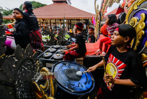 Seniman musik memainkan gamelan dan bas yang terbuat dari tong plastik saat menampilkan aksi terbaiknya di depan gedung Cak Durasim, Taman Budaya, Surabaya, Jawa Timur. Kamis (9/3/2023). Para seniman tersebut menunjukkan aksinya dalam rangka Hari Musik Nasional yang jatuh tiap tanggal 9 Maret. (Foto: Moch Sahirol Layeli)