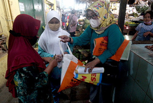 Aktivis Komunitas Nol Sampah dan siswa SDN Kertajaya IV Surabaya bahu membahu memberikan pengarahan pada warga untuk menganti tas kresek dengan tas kain.